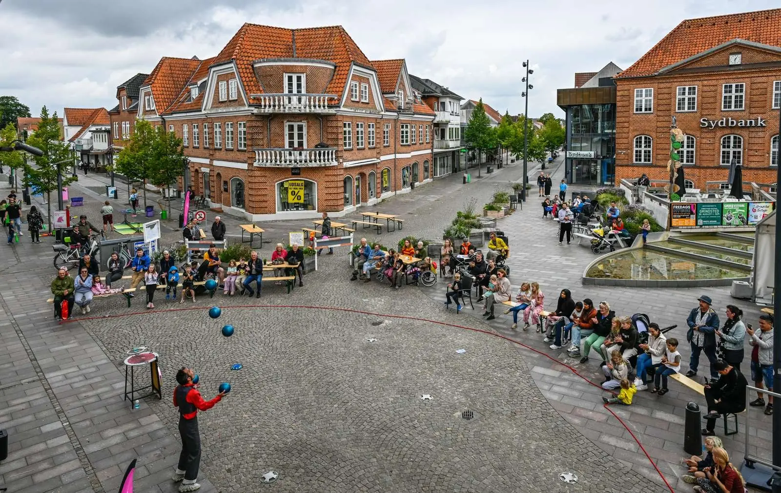 Audience watching a street performer on the square in Grindsted